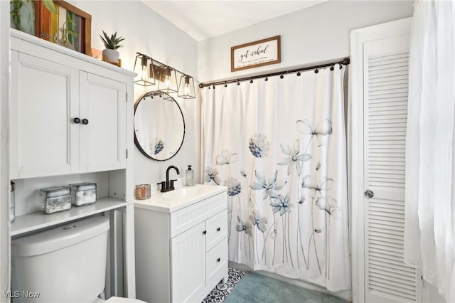 full bathroom with a closet, vanity, and toilet