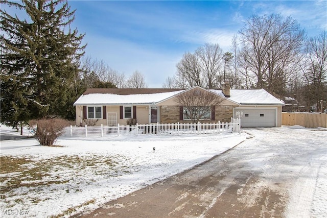 ranch-style home with a garage and a fenced front yard