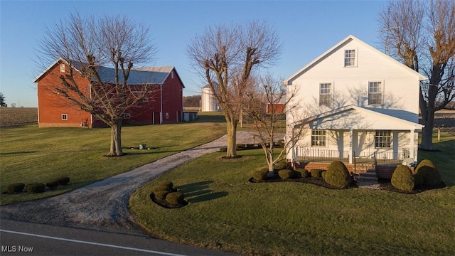 view of front of property featuring driveway, a front lawn, and a porch