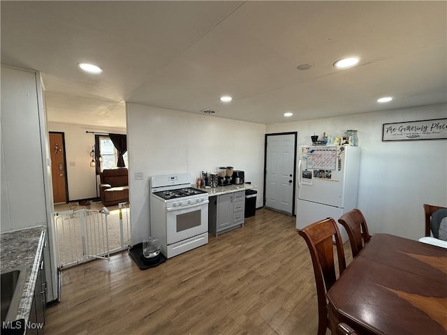 kitchen featuring white appliances, gray cabinets, dark wood finished floors, and recessed lighting