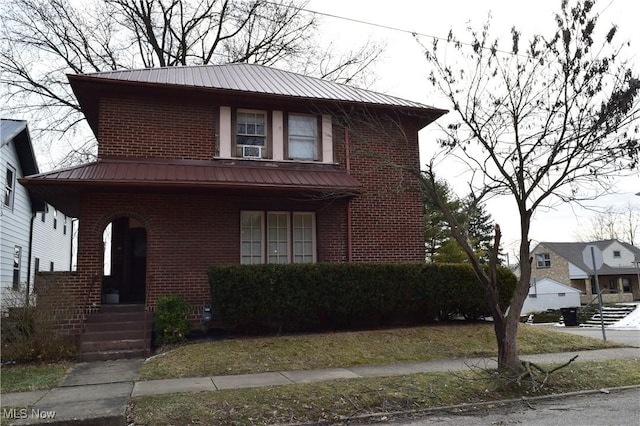 view of front of house featuring brick siding and metal roof