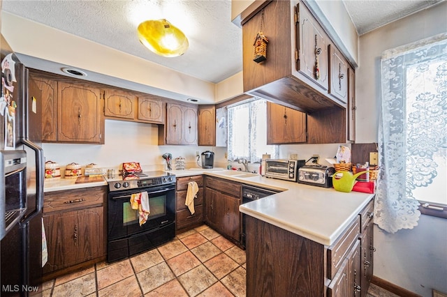 kitchen featuring light countertops, a textured ceiling, and black appliances