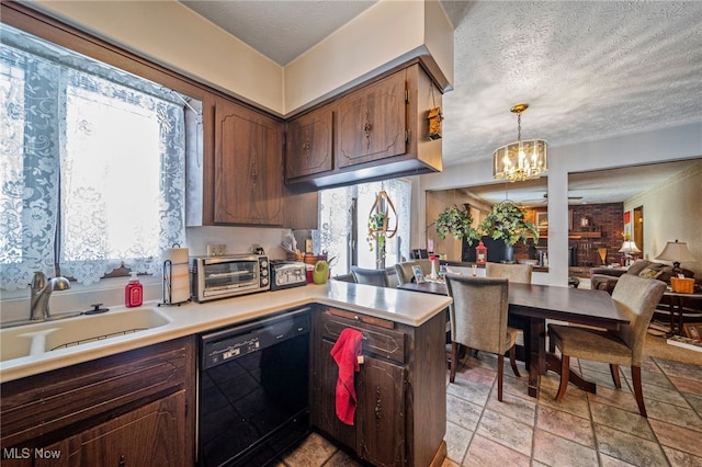 kitchen with black dishwasher, light countertops, hanging light fixtures, a sink, and a peninsula