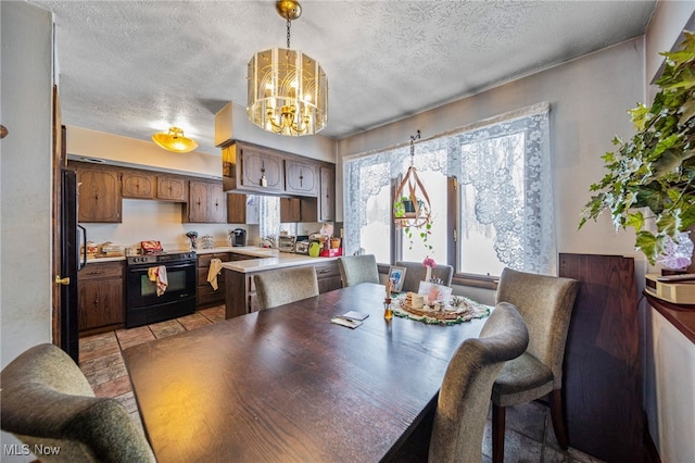 dining room featuring a chandelier and a textured ceiling