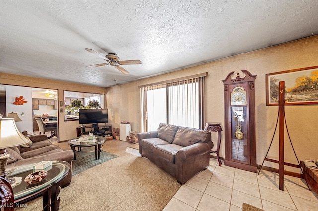 living room featuring light tile patterned floors, ceiling fan, and a textured ceiling