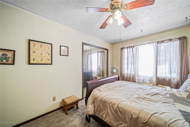 carpeted bedroom with a ceiling fan, a textured ceiling, and baseboards