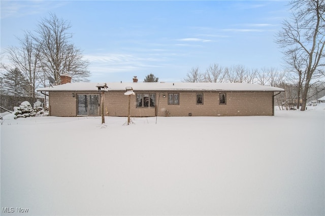 view of snow covered back of property