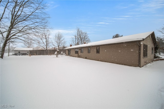 view of snow covered back of property