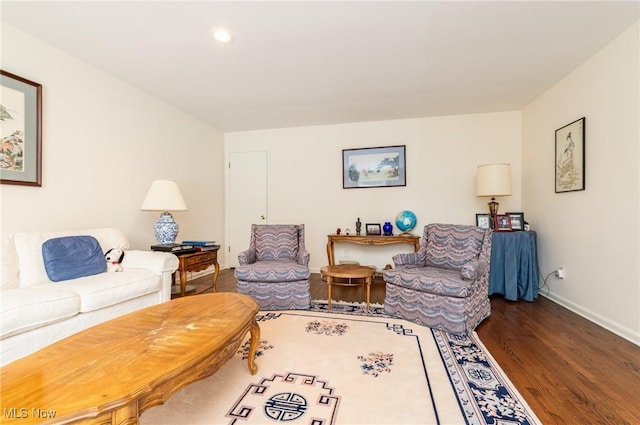 living area with dark wood-style flooring and baseboards