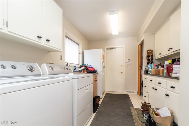 clothes washing area featuring cabinet space, washing machine and clothes dryer, and light tile patterned flooring