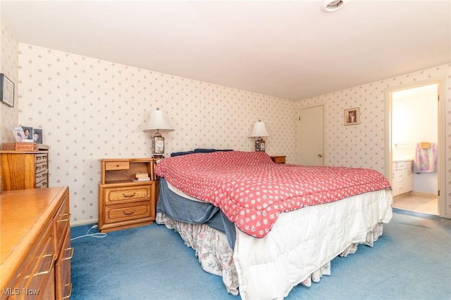 bedroom featuring dark colored carpet, connected bathroom, baseboards, and wallpapered walls