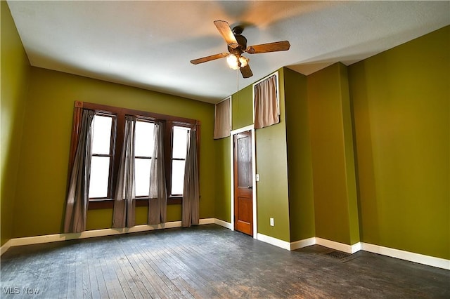 unfurnished room with dark wood-style floors, baseboards, and a ceiling fan