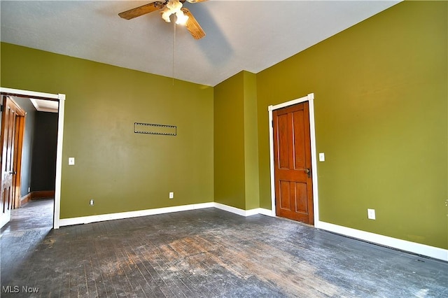 unfurnished room featuring dark wood-style floors, ceiling fan, and baseboards