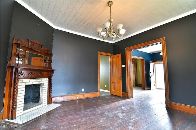 unfurnished living room featuring baseboards, a fireplace, ornamental molding, and wood finished floors