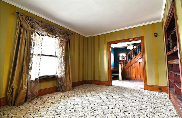 empty room with stairway, baseboards, and ornamental molding