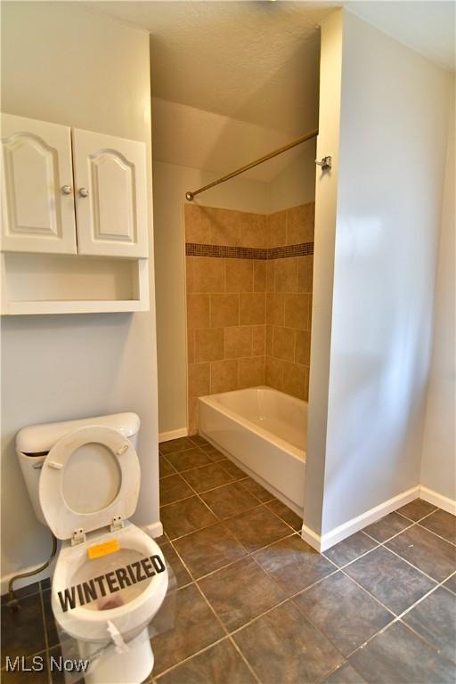 full bathroom with  shower combination, tile patterned flooring, toilet, and baseboards