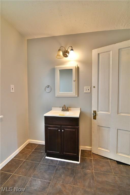 bathroom featuring tile patterned flooring, baseboards, and vanity