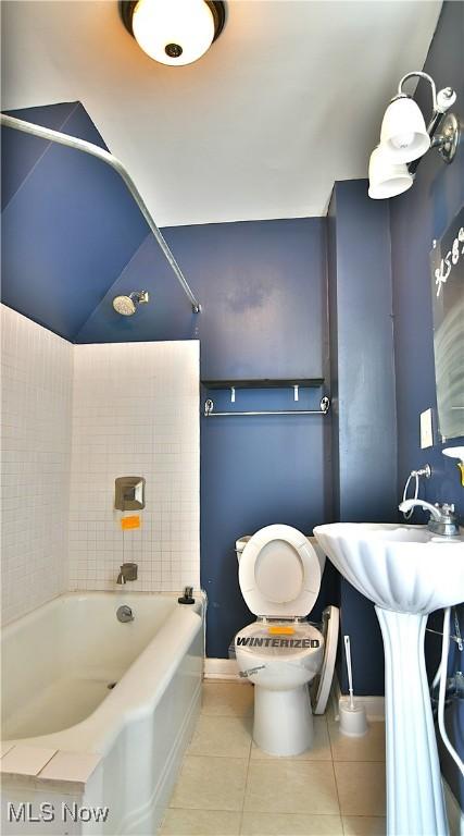 bathroom with baseboards, shower / bath combination, toilet, and tile patterned floors