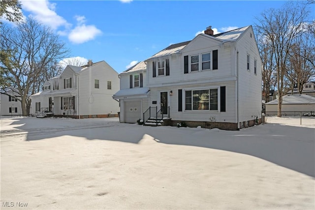 view of front of home featuring a chimney and an attached garage