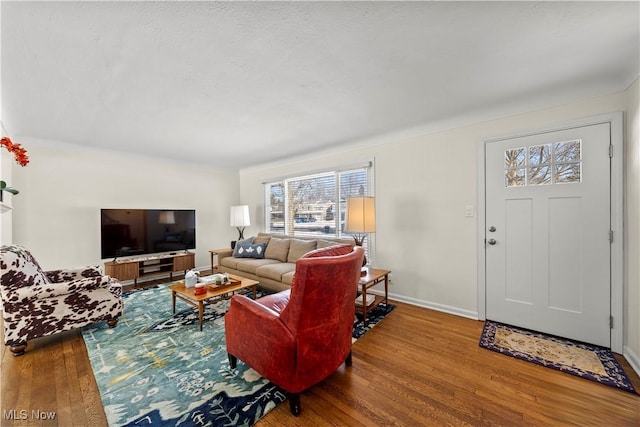 living area featuring baseboards and wood finished floors