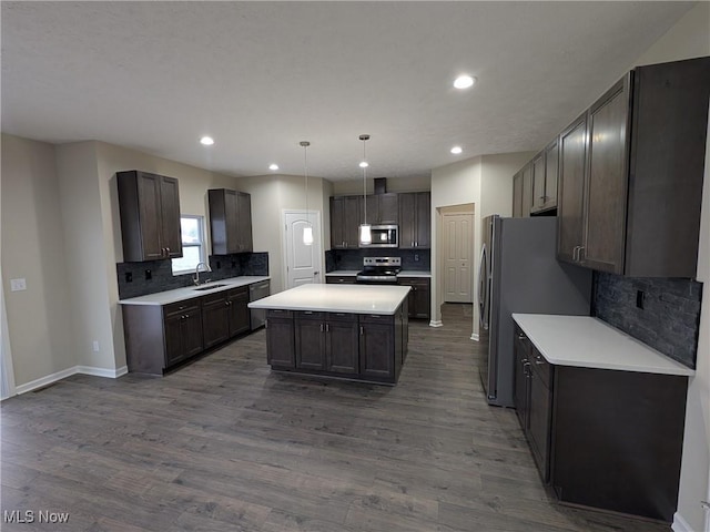 kitchen with a sink, light countertops, appliances with stainless steel finishes, a center island, and pendant lighting