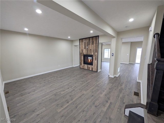 unfurnished living room with a tile fireplace, recessed lighting, wood finished floors, visible vents, and baseboards