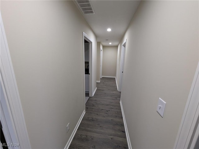 hallway with dark wood-style floors, recessed lighting, visible vents, and baseboards