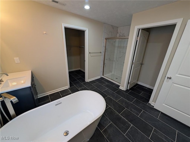 full bath with vanity, visible vents, baseboards, a soaking tub, and a stall shower