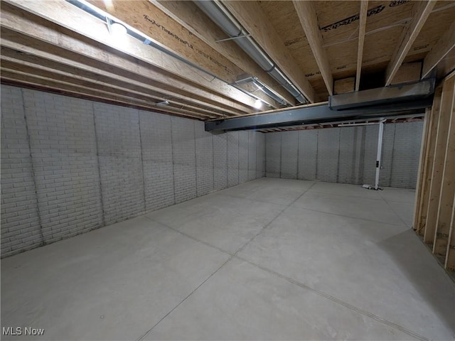 unfinished basement featuring brick wall