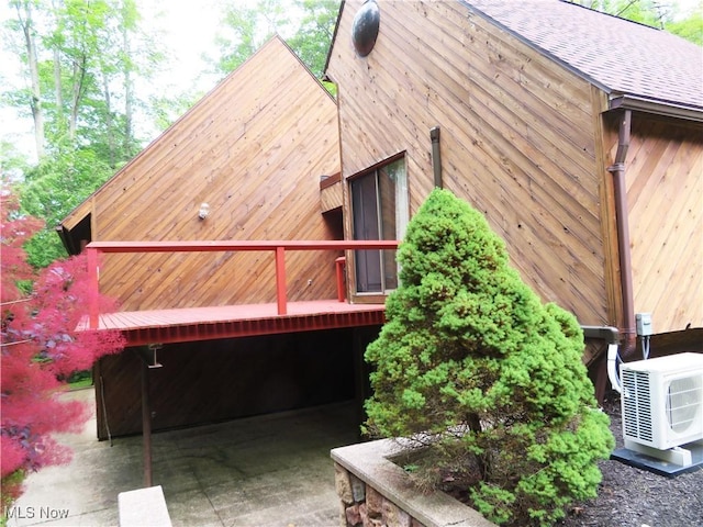 view of property exterior with ac unit and roof with shingles