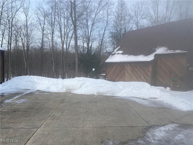 snowy yard featuring an outdoor structure