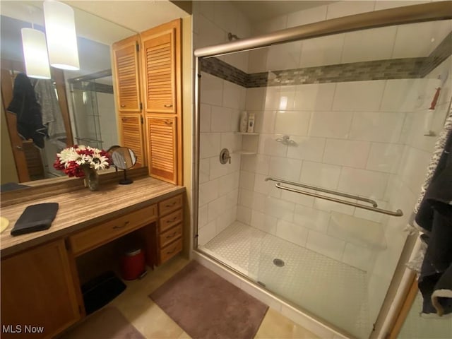 bathroom with a closet, vanity, and a shower stall