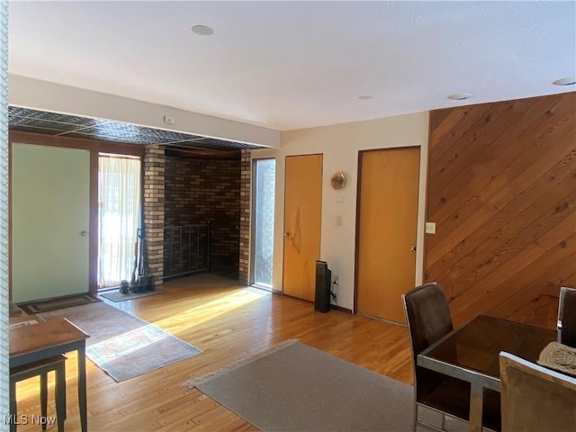 interior space featuring light wood-type flooring, a fireplace, and wooden walls