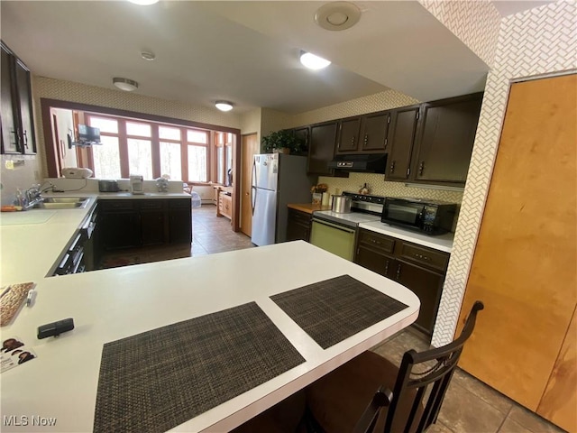 kitchen with black microwave, extractor fan, a peninsula, electric range, and light countertops