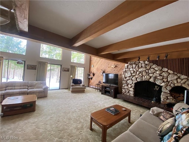 carpeted living room featuring a fireplace and beam ceiling