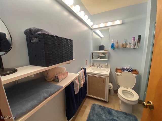 bathroom with toilet, vanity, and tile patterned floors