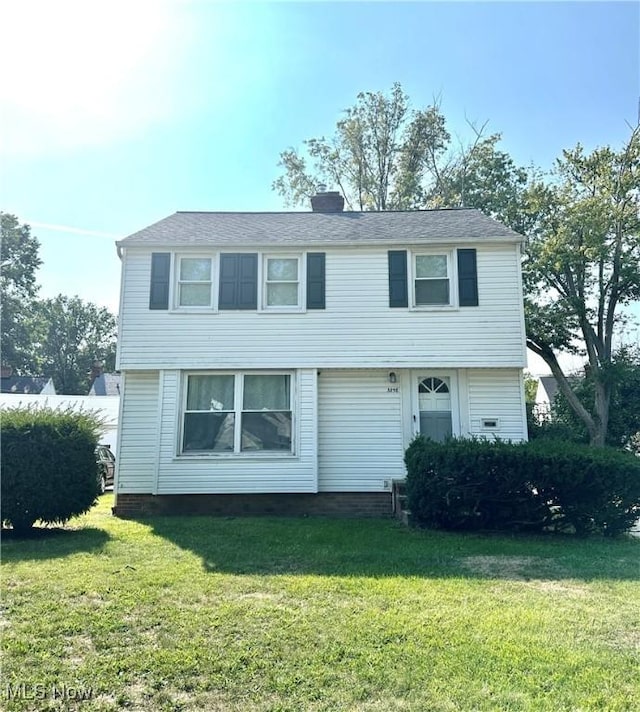 colonial home with a front lawn and a chimney