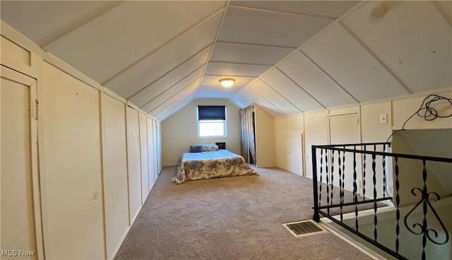 unfurnished bedroom with vaulted ceiling, carpet floors, and visible vents