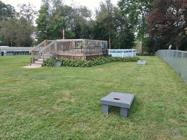 exterior space featuring an outdoor pool, fence, and a deck