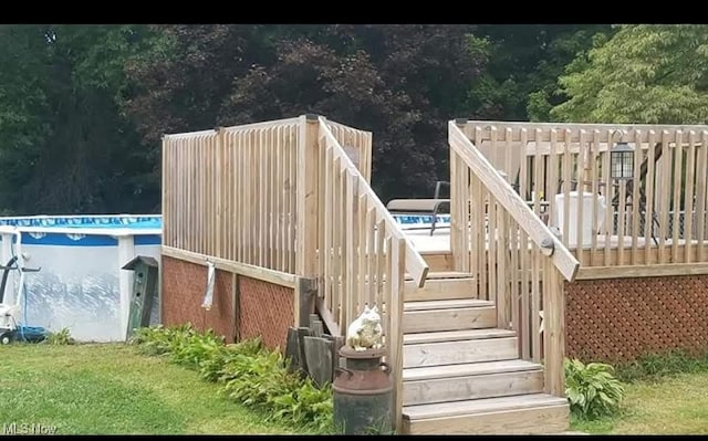 wooden deck featuring a lawn