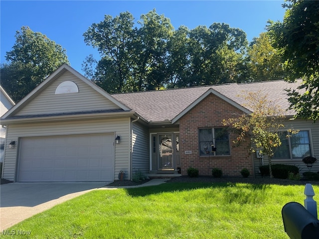 single story home with a garage, a front yard, brick siding, and driveway