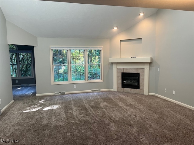 unfurnished living room with carpet floors, a fireplace, visible vents, and vaulted ceiling