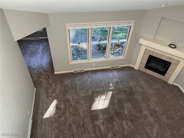 unfurnished living room with carpet floors, a fireplace, and visible vents