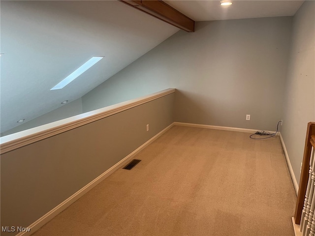 bonus room featuring light carpet, lofted ceiling with skylight, baseboards, and visible vents