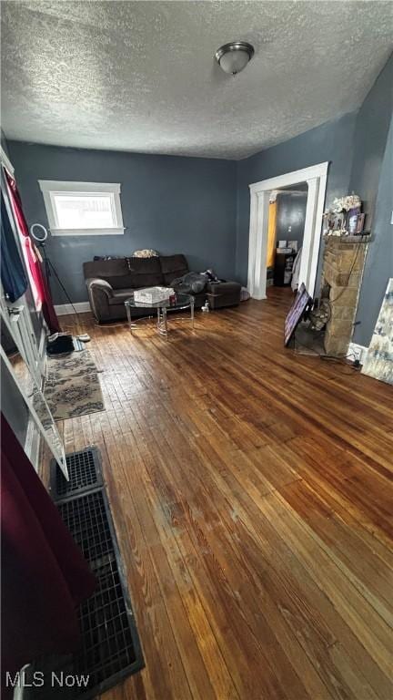 unfurnished living room with a textured ceiling and wood finished floors