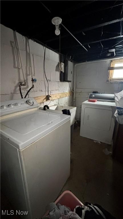 washroom with washing machine and dryer, laundry area, and a sink