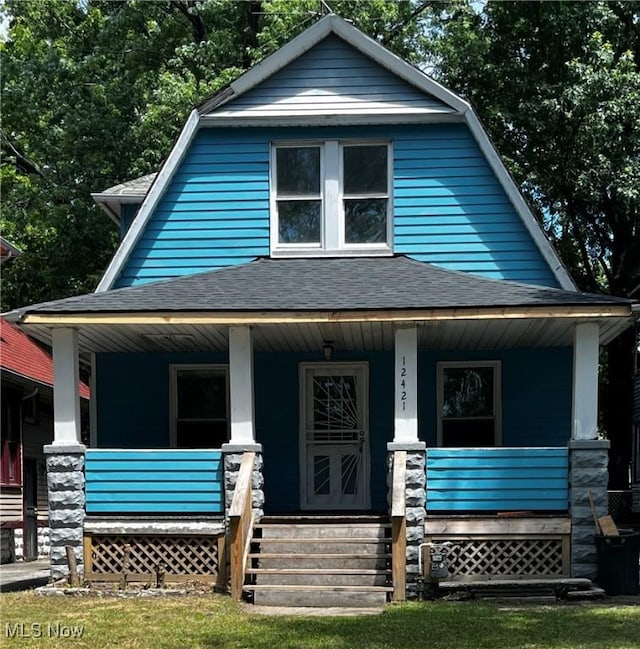 view of front facade featuring a porch, roof with shingles, and a gambrel roof