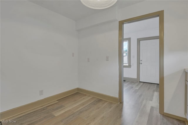 empty room featuring light wood-type flooring and baseboards