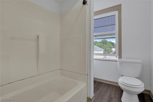 bathroom with shower / bathtub combination, wood finished floors, and toilet