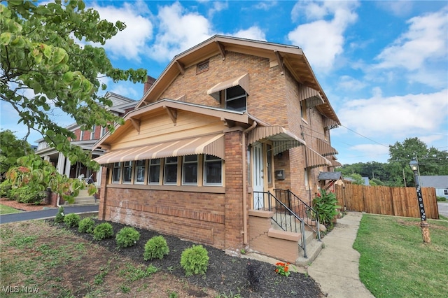 view of front facade with fence and brick siding